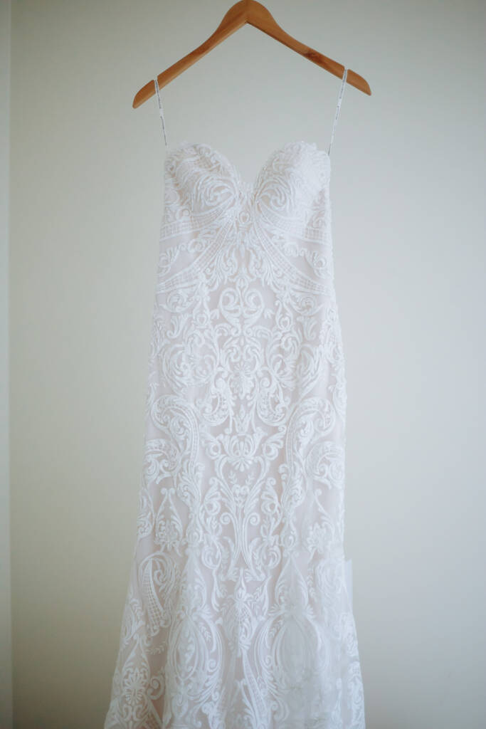 The strapless lace gown waits on its timber hanger