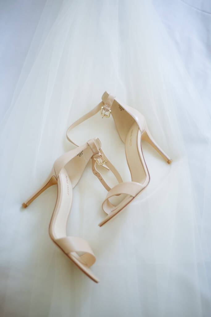Ankle-strap heels rest on a drift of tulle