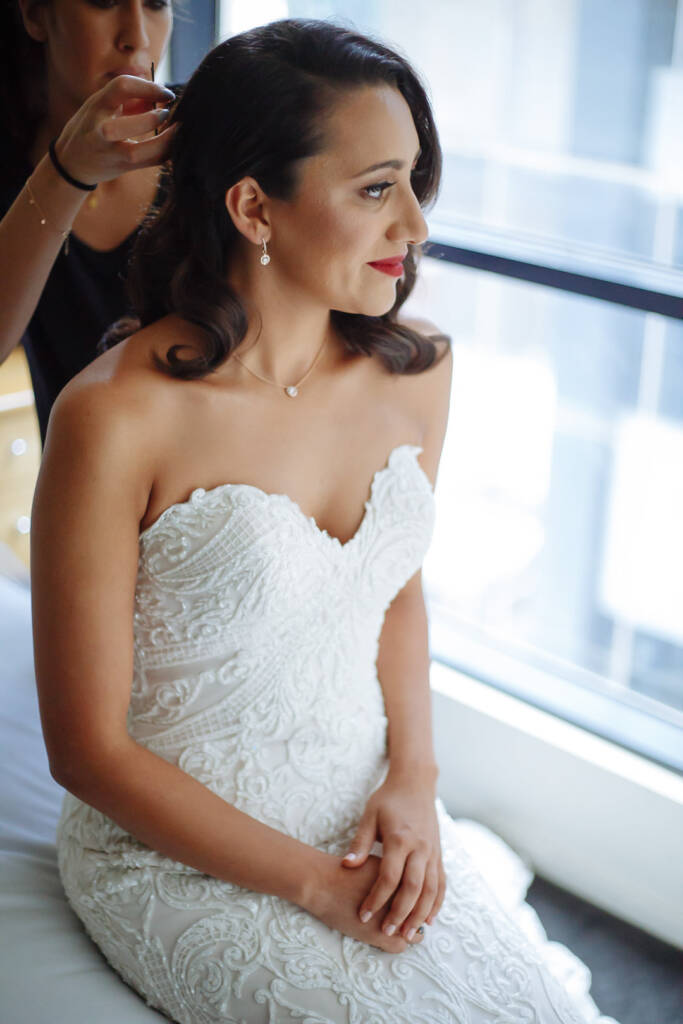 Red lips and rolled curls above the sweetheart beaded bodice