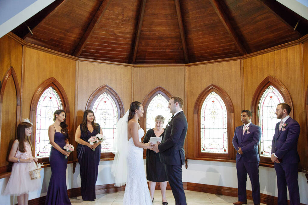The full wedding party rings the octagonal chapel for the vows