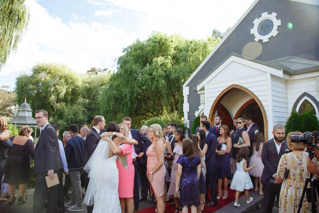 The crowd spills from the chapel arch into the afternoon sun