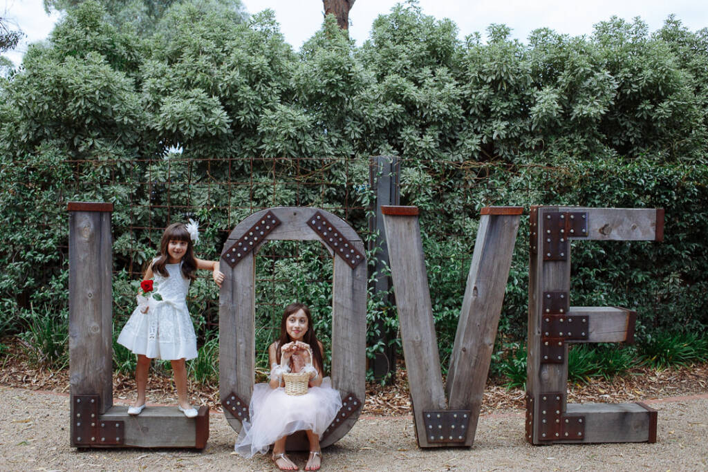 Two flower girls own the giant rustic LOVE letters