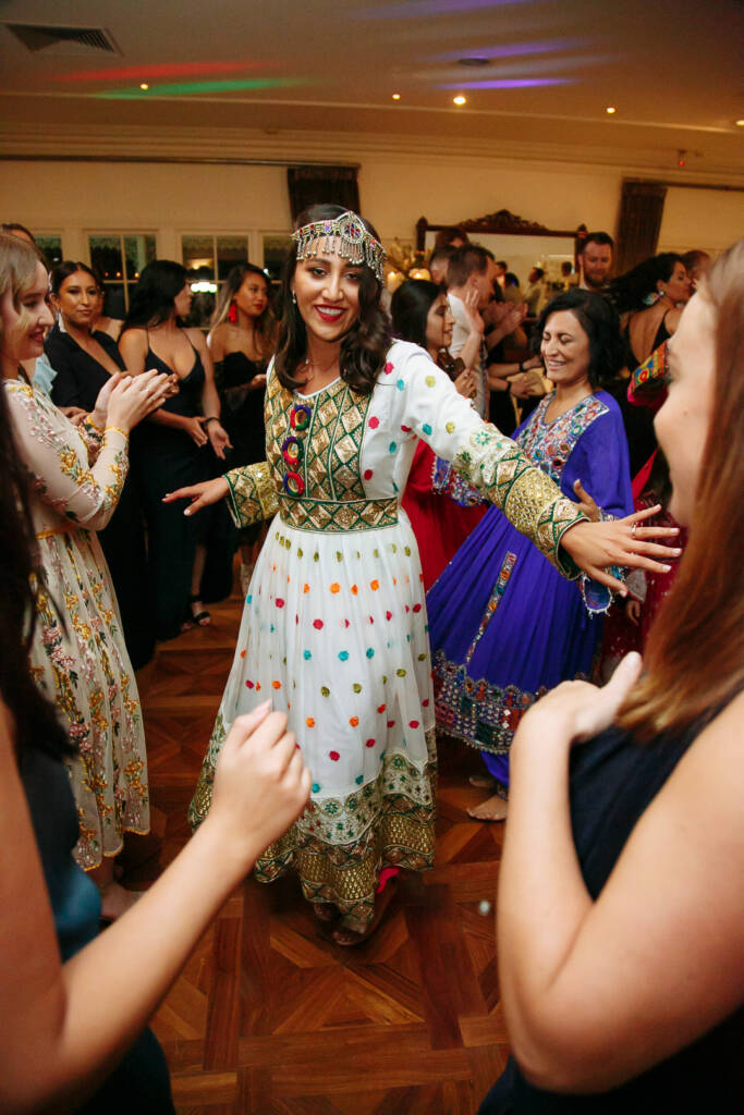 Polka dot skirts flare as the bride dances between guests in navy and embroidered blue.
