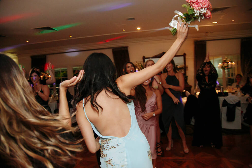 One triumphant arm hoists the caught roses overhead