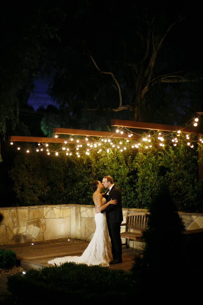 A last kiss on the festoon-lit garden stage in the dark