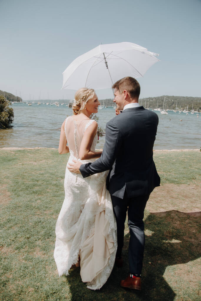 Emma and Sean smile beneath a white sun umbrella near Bayview Yacht Racing Association.