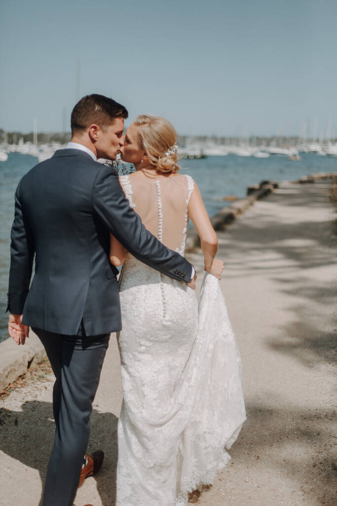 Emma and Sean kiss while walking beside Pittwater near Bayview Yacht Club.