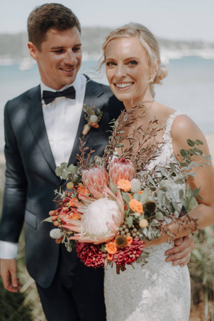 Emma and Sean smile together over her protea and foliage bouquet.