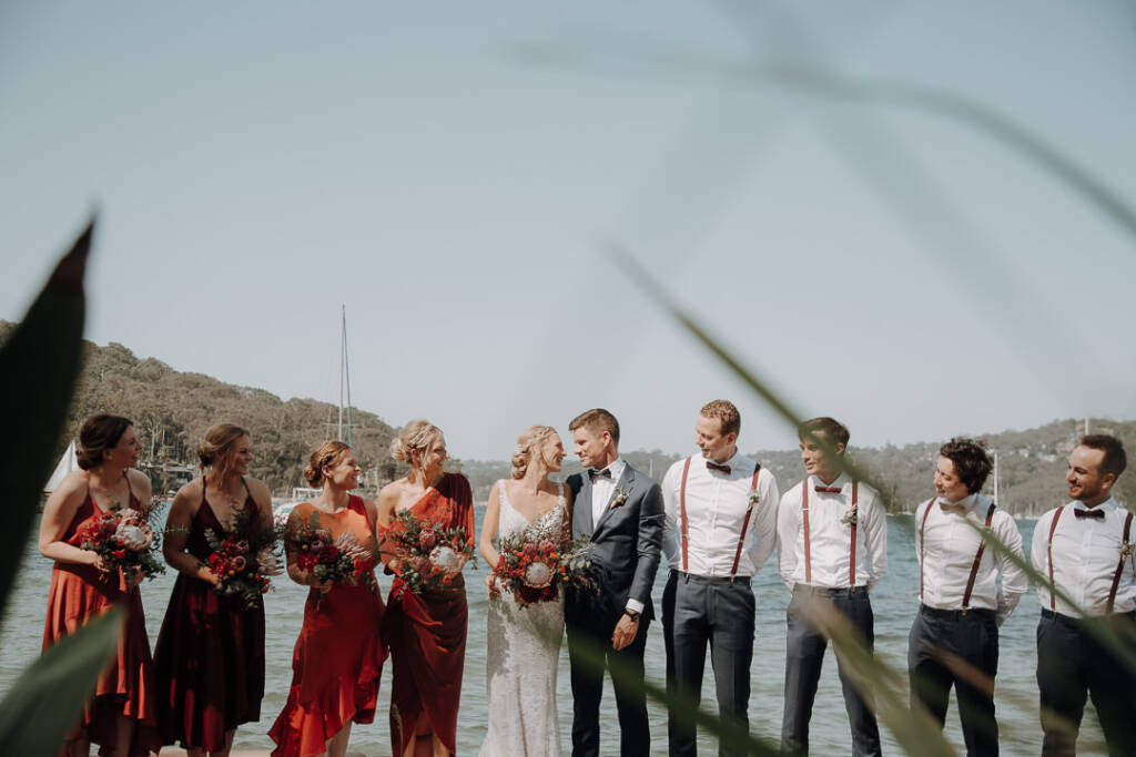Foliage frames the wedding party beside the water near Bayview Yacht Club.