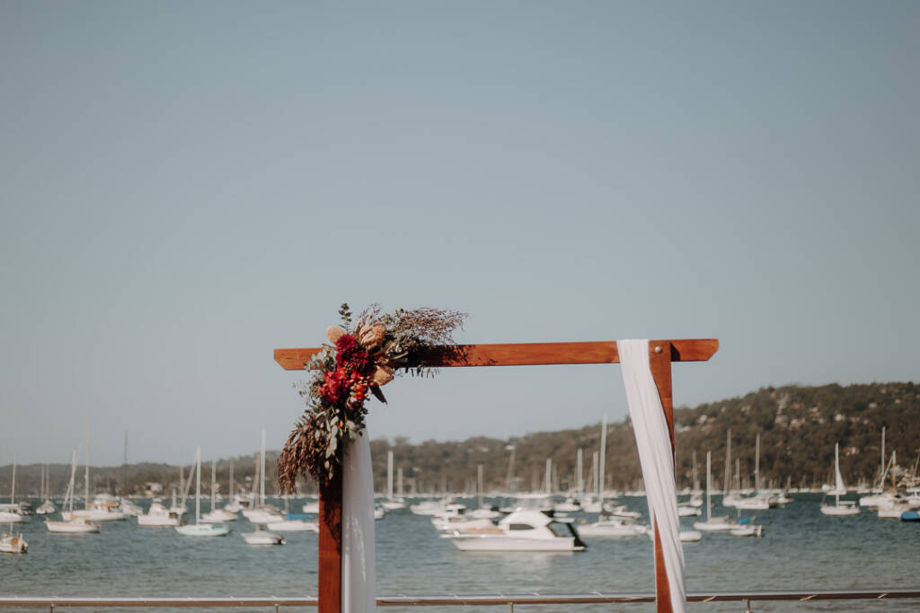 Flowers and white draping decorate the timber ceremony arbour on Bayview Yacht Racing Association’s deck.