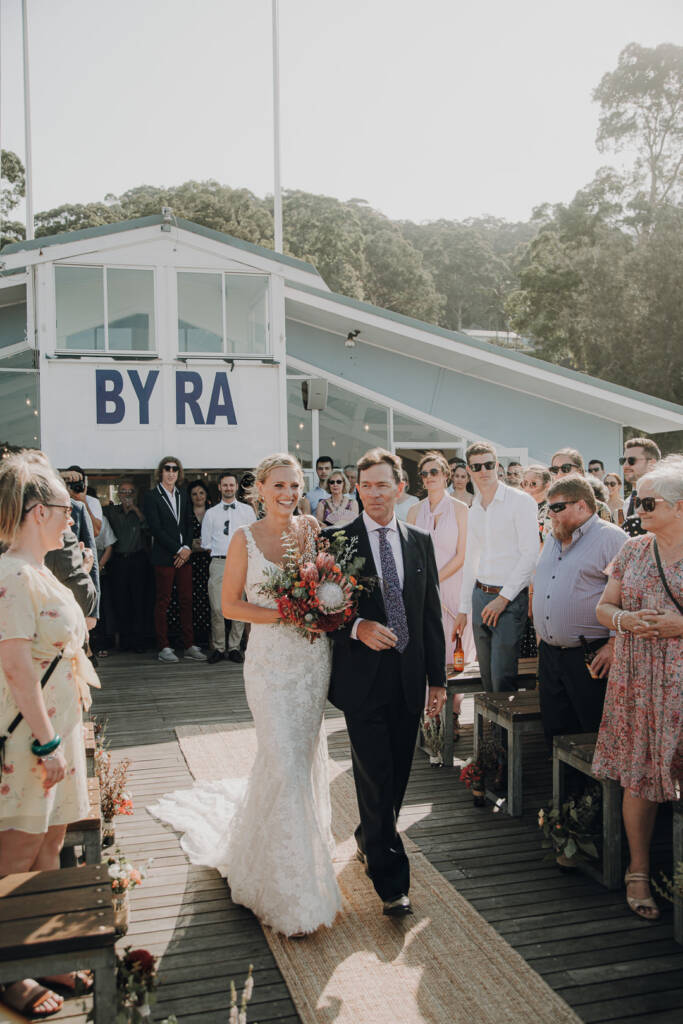 Emma is escorted along the woven aisle runner on Bayview Yacht Club’s ceremony deck.
