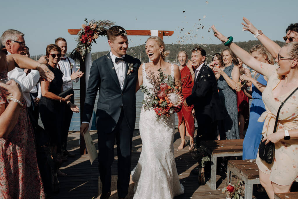 Guests throw dried confetti as Emma and Sean leave the ceremony at Bayview Yacht Racing Association.