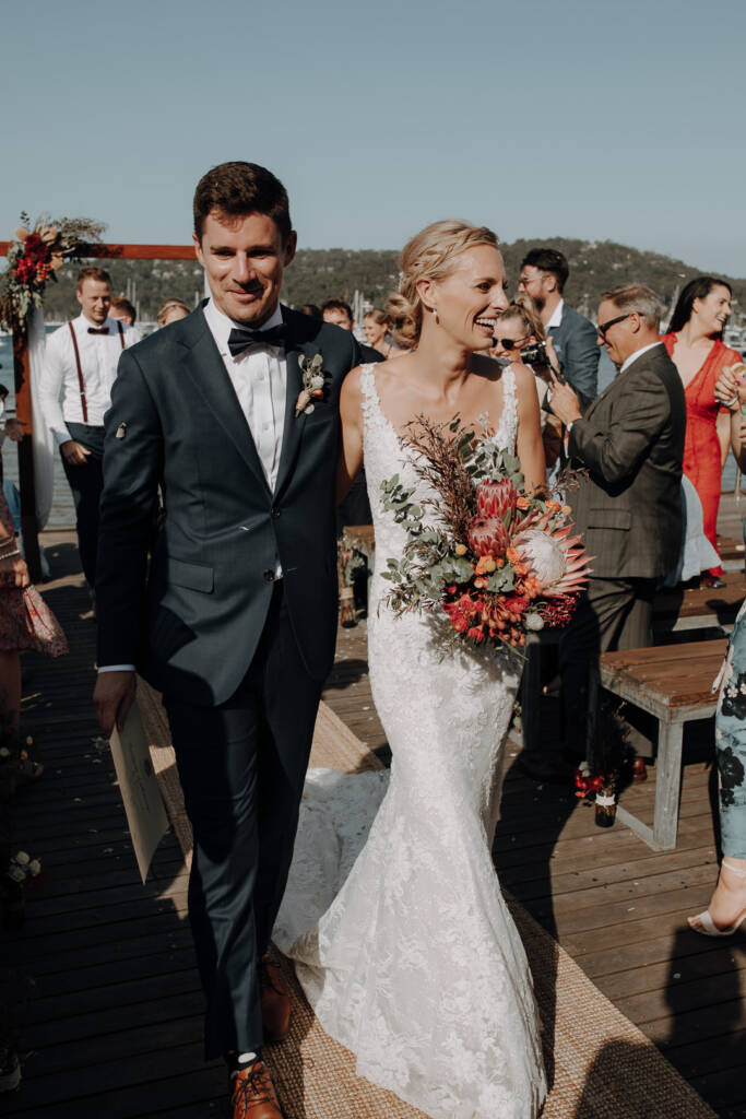 Emma and Sean smile as they walk along BYRA’s woven aisle runner after the ceremony.