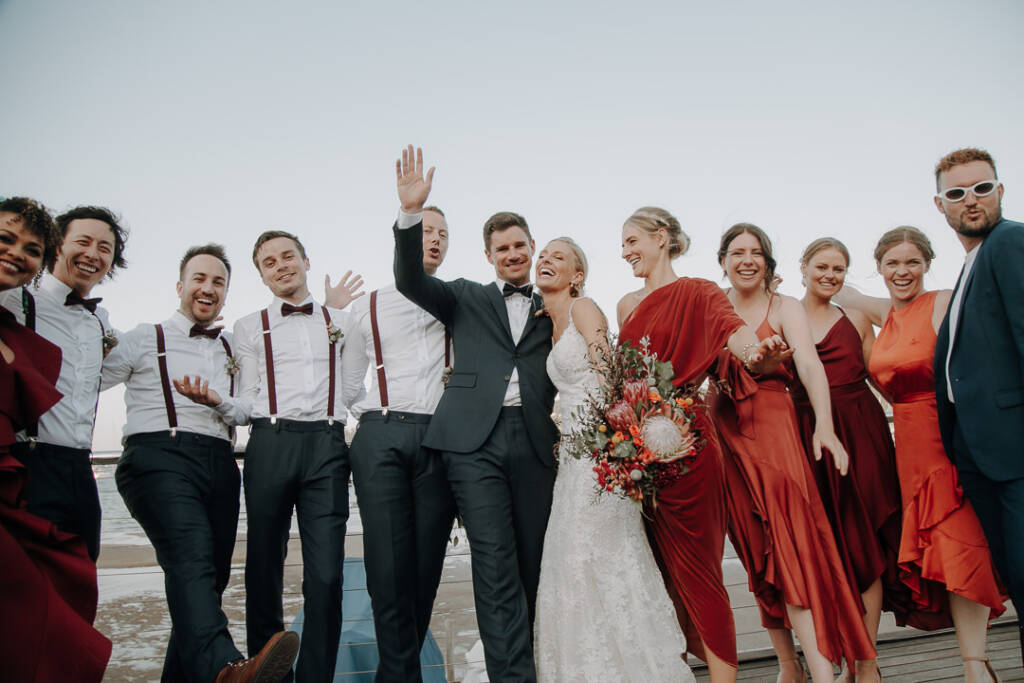 Sean raises an arm as the wedding party laugh together on Bayview Yacht Racing Association’s deck.