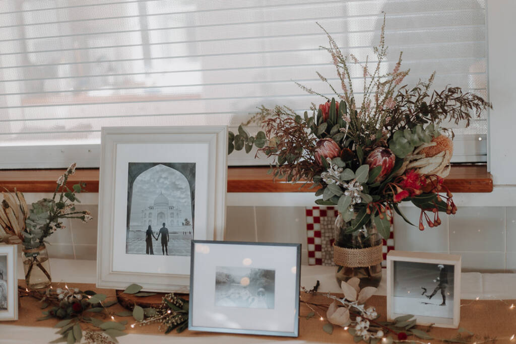 Framed travel photographs, flowers and fairy lights decorate a ledge at Bayview Yacht Racing Association.