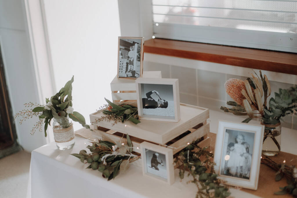Framed photographs sit on timber crates with banksia and foliage at BYRA’s reception.