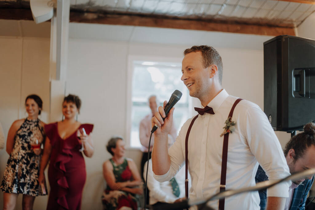 A wedding attendant speaks into a microphone inside BYRA’s clubhouse.
