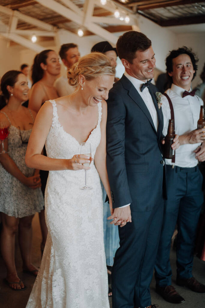 Emma and Sean look down laughing beneath Bayview Yacht Club’s festoon lights.