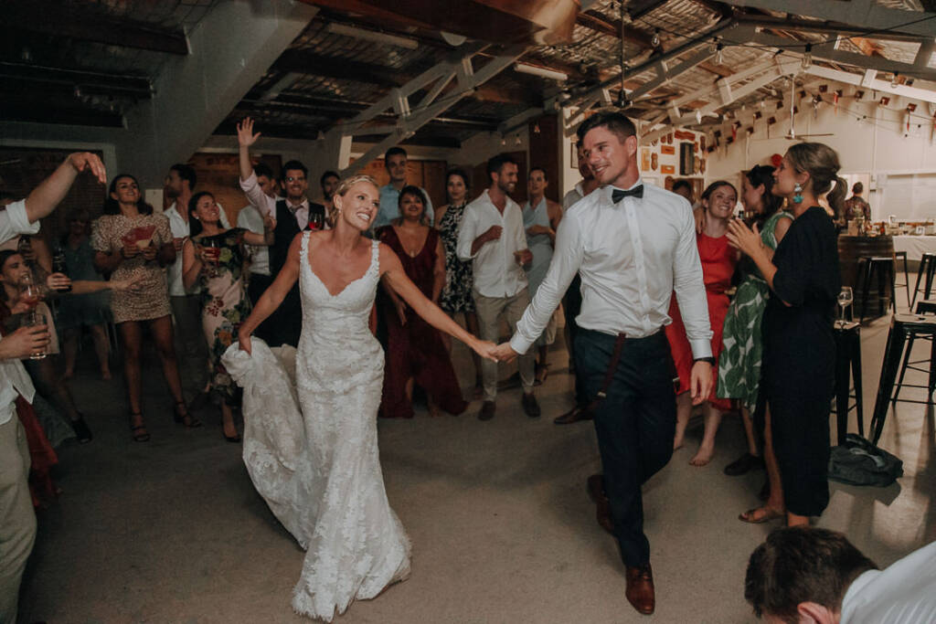 Emma lifts her skirt and holds Sean’s hand as they dance at Bayview Yacht Club.