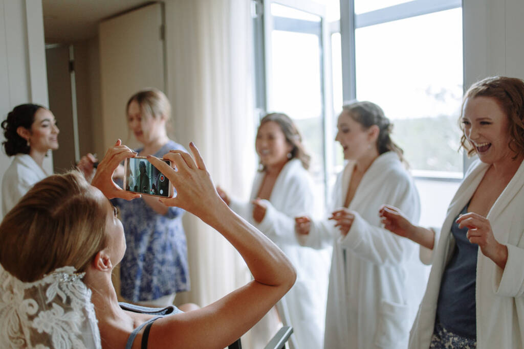 Becky photographs members of her bridal party in matching robes during wedding preparations.