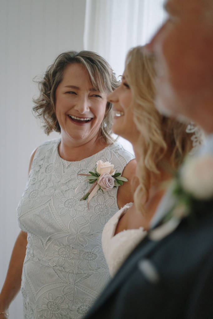 Becky shares a warm preparation moment with a smiling loved one wearing a floral corsage.