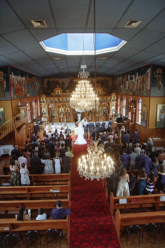 Wide balcony view of Becky and George's Greek Orthodox ceremony inside St Nicholas Greek Orthodox Church.