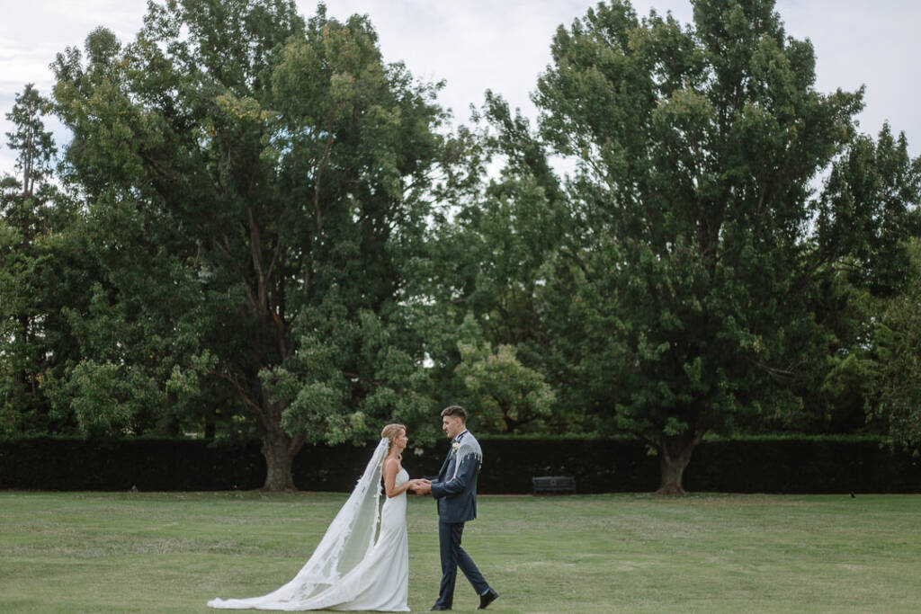Becky and George face each other beneath mature trees at Senate Gardens Canberra.