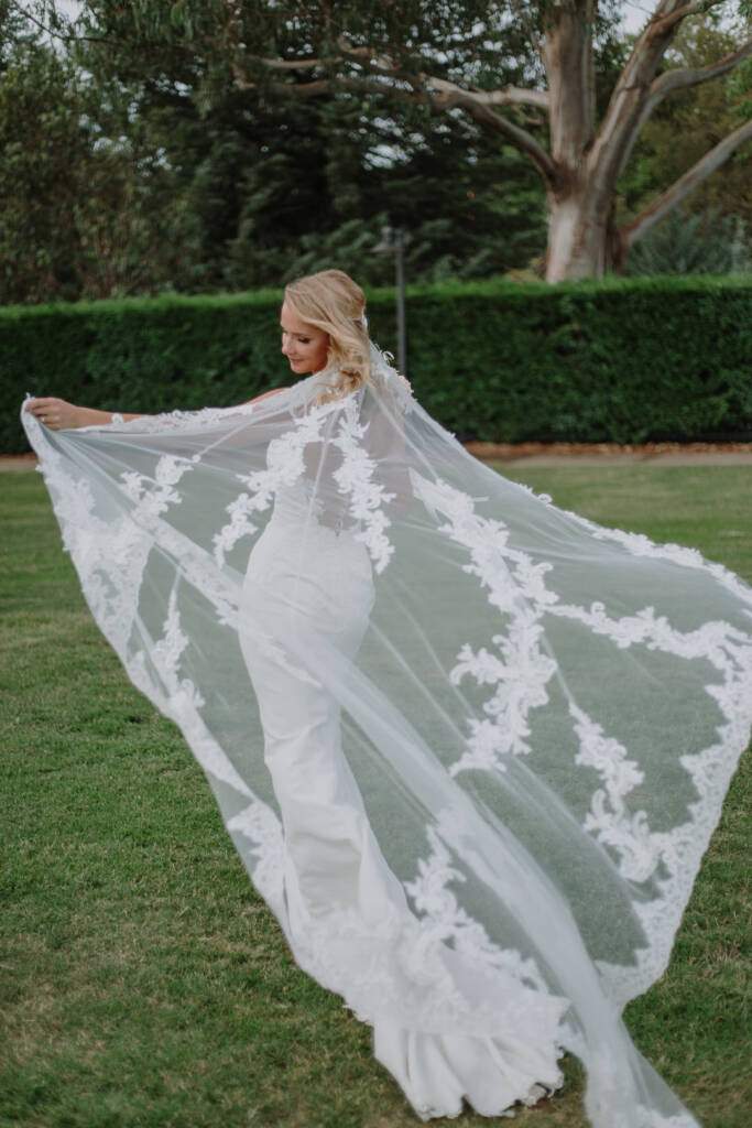 Becky spreads her long lace veil across the lawn at Old Parliament House Rose Gardens.