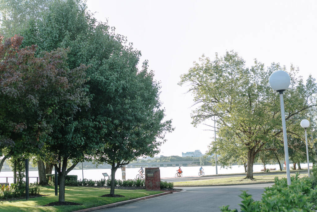 Tree-lined grounds at The Boat House frame Lake Burley Griffin in soft evening light.
