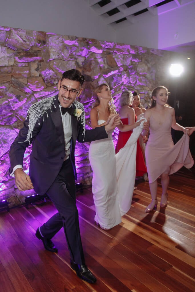 George leads guests onto the purple-lit dance floor at The Boat House by the Lake.