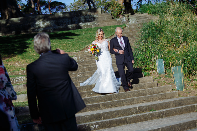 Sabine walks arm in arm with an older man down Bradleys Head Amphitheatre's steps