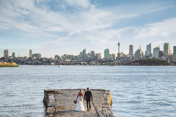 Sabine and Arthur walk along the Bradleys Head jetty towards the Sydney skyline