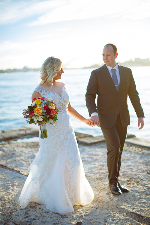 Sabine and Arthur walk across sunlit sandstone at Bradleys Head on Sydney's North Shore