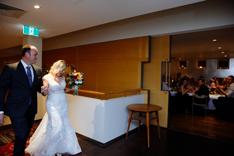 Sabine and Arthur enter the reception holding hands at Bathers'