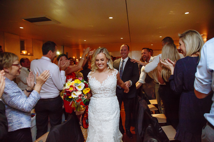 Sabine leads Arthur between applauding guests at their Bathers' Pavilion reception