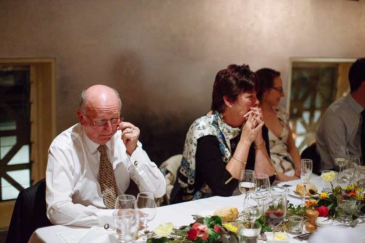 A seated guest adjusts his glasses beside a woman at Bathers'