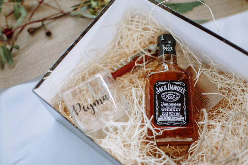 A small whisky bottle, engraved tumbler and folding tool rest in a gift box.