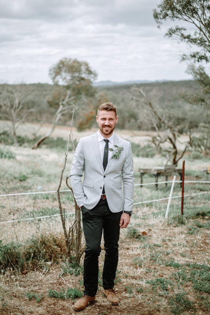 Tory stands beside a wire fence overlooking the bush grounds at Camp Sunnystones near Bacchus Marsh.