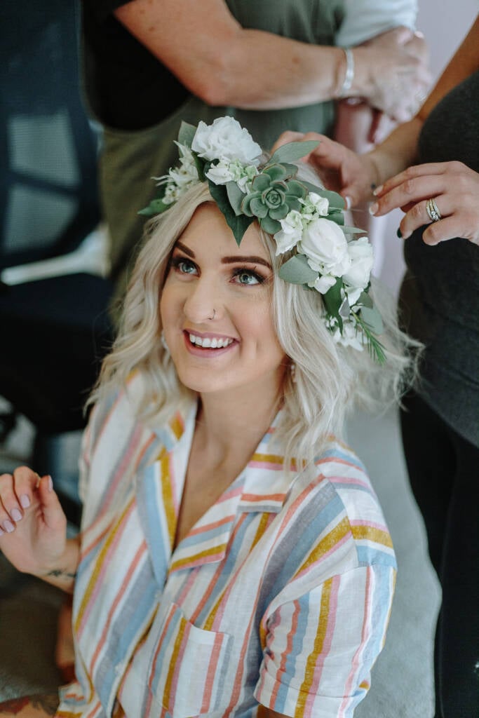 Kelly smiles as her rose and succulent flower crown is adjusted.