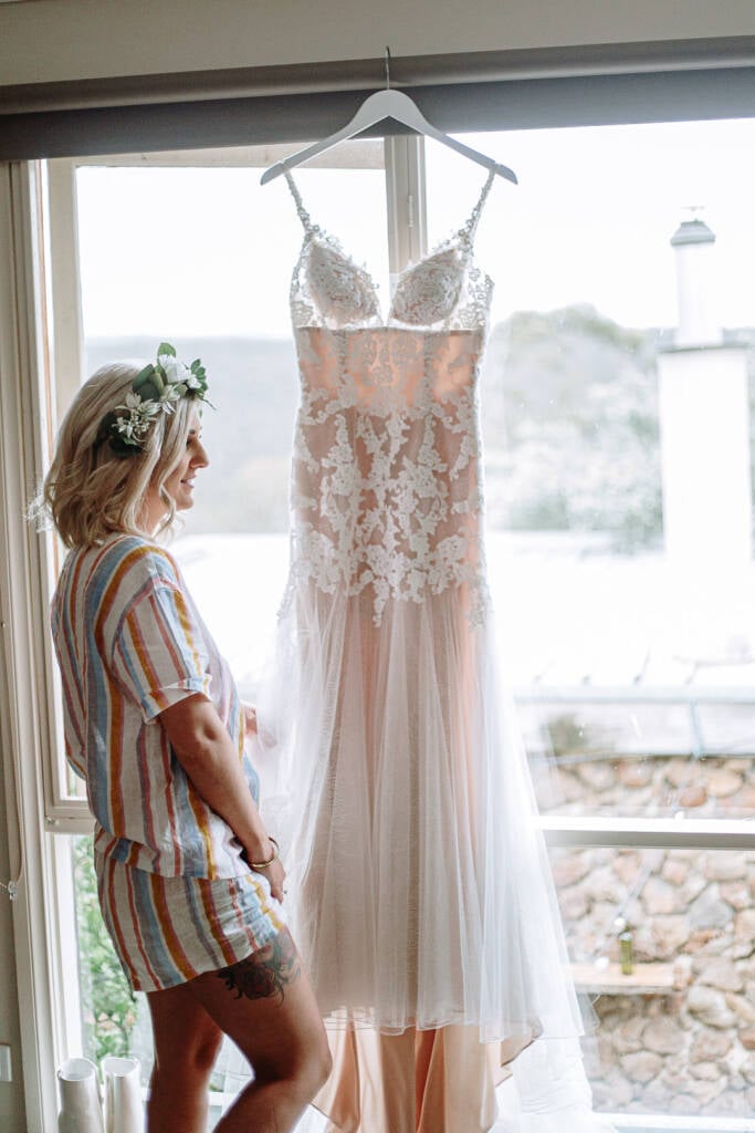 Kelly looks towards her hanging wedding gown during preparation at Camp Sunnystones.