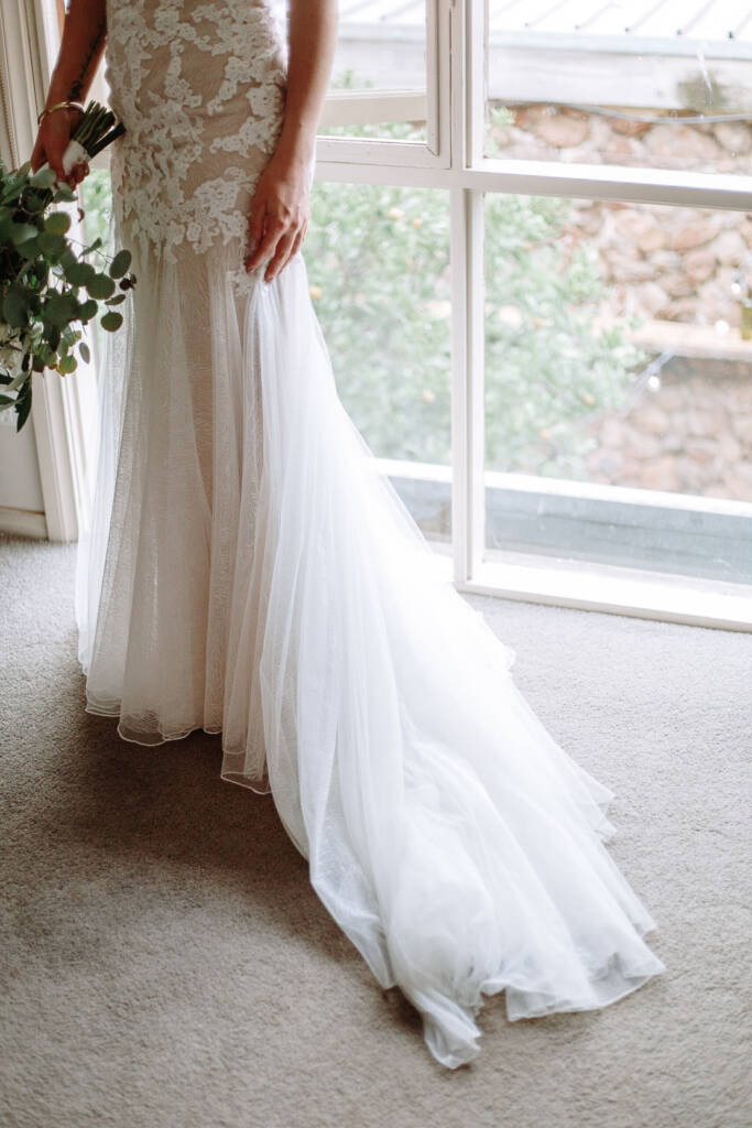 Kelly’s lace gown and train catch the window light at Sunnystones.
