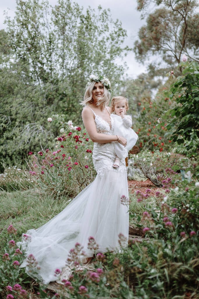 Kelly carries a child through the flower garden at Sunnystones.