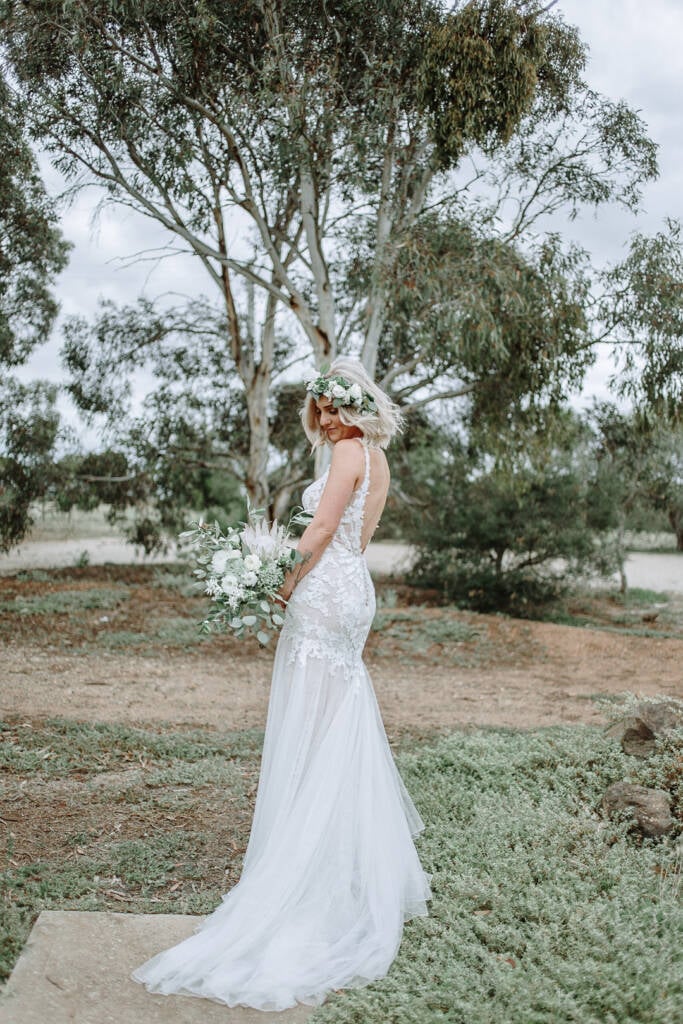 Kelly poses beneath the trees in her lace gown at Camp Sunnystones.