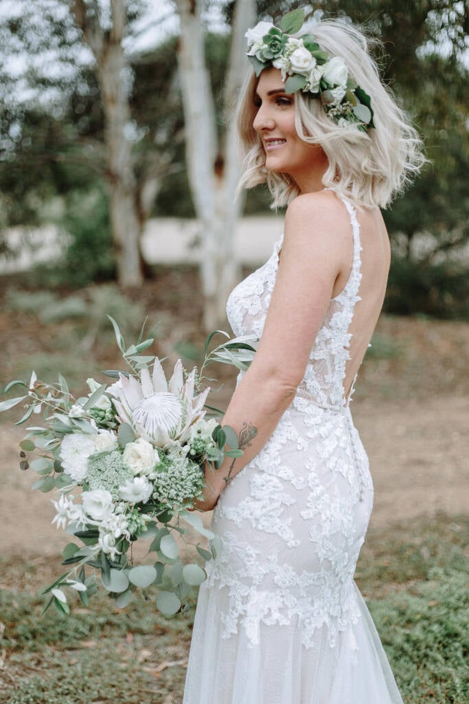 Kelly looks over her shoulder beneath her rose and succulent flower crown.