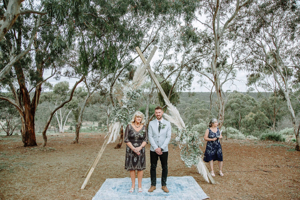 Tory waits beside a guest beneath the timber ceremony arbour at Sunnystones.