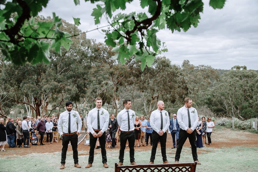 Five wedding attendants stand together on the lawn at Camp Sunnystones.