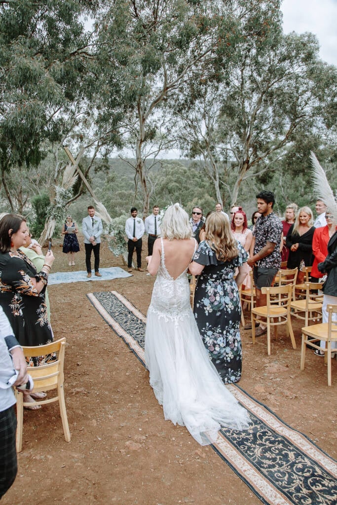 Kelly is escorted along the rug aisle during her country wedding at Camp Sunnystones.