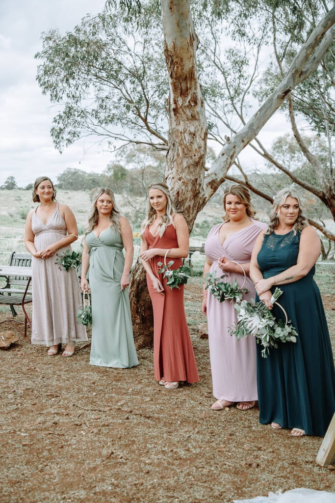 Wedding attendants hold foliage hoops beneath a large tree at Sunnystones.