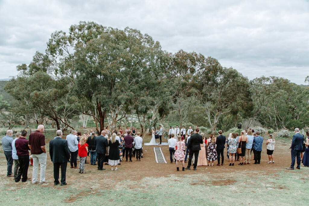 Guests gather around the outdoor country wedding ceremony at Sunnystones near Bacchus Marsh.