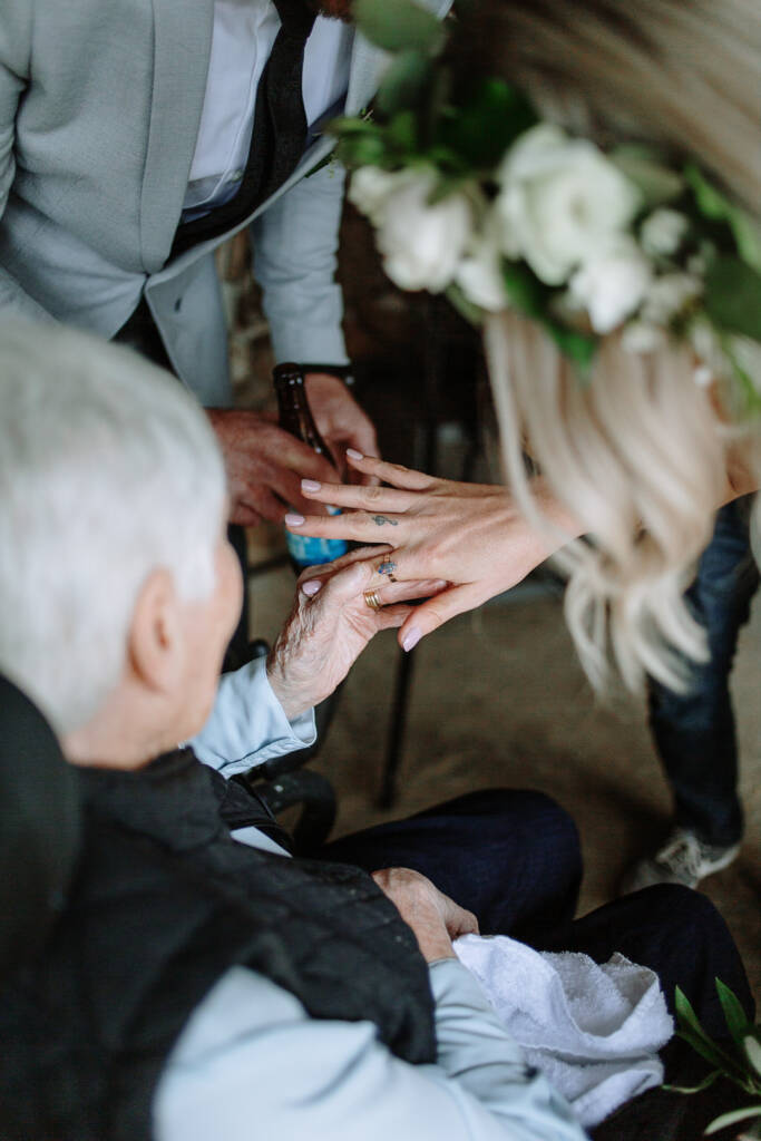 Kelly shows her wedding ring to a seated guest after the ceremony.